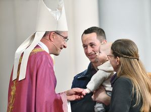 Ellen und Tobias Büdel mit Theo begrüßen Bischof Gerber im Festgottesdienst - stellvertretend für alle Familien 
